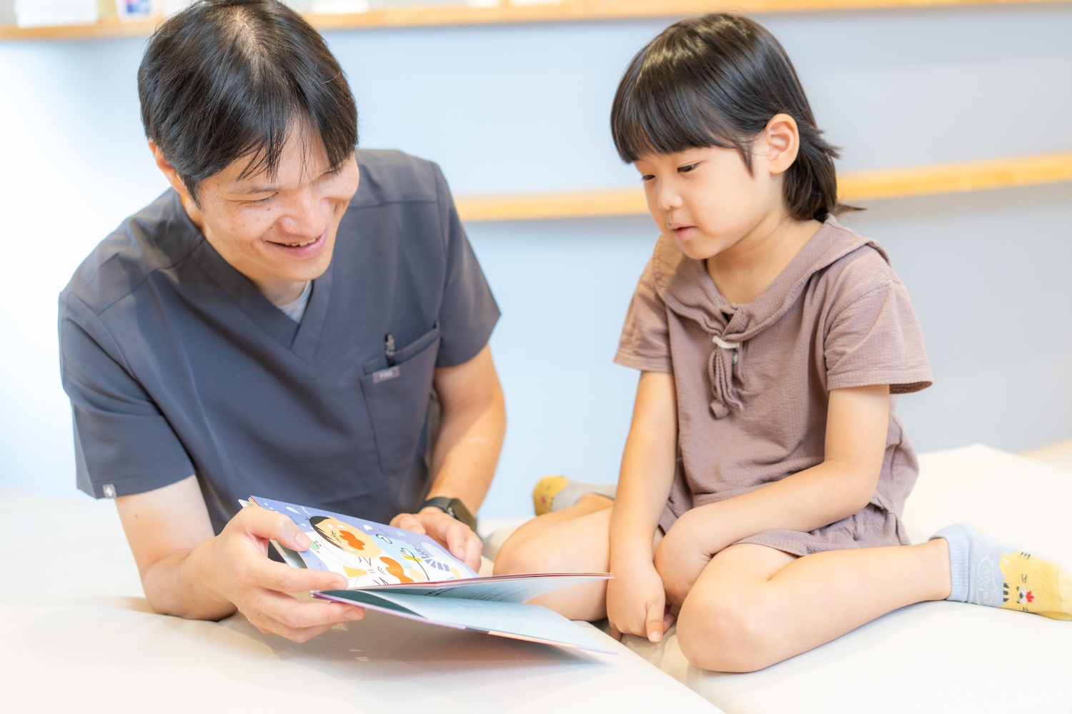 子どもと一緒に絵本を見る佐野先生